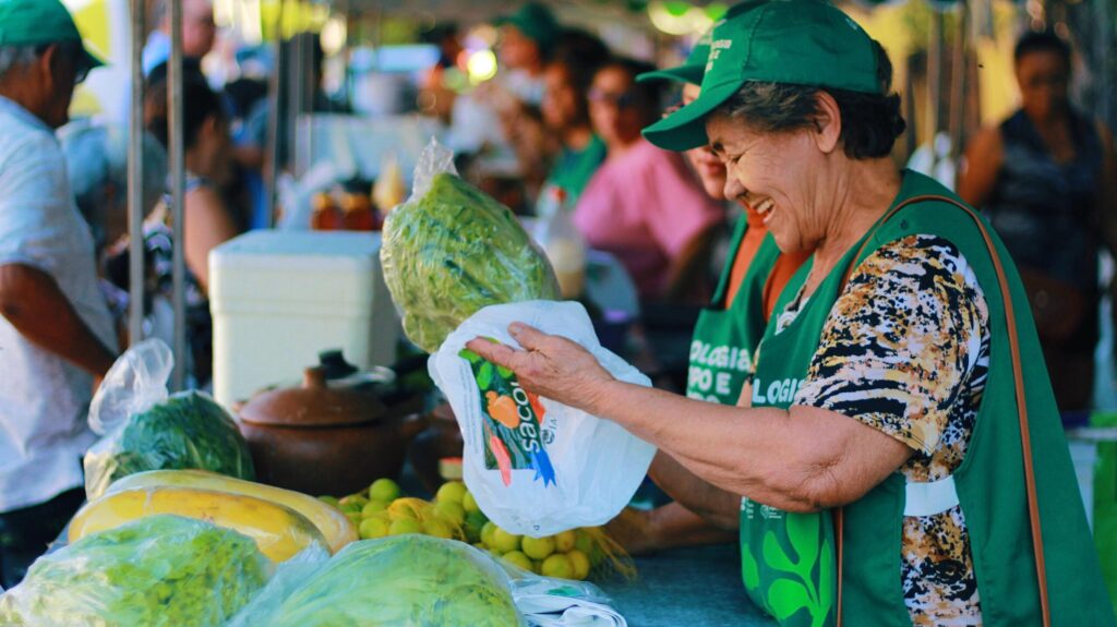 Agricultora comercializando mamão na feira.