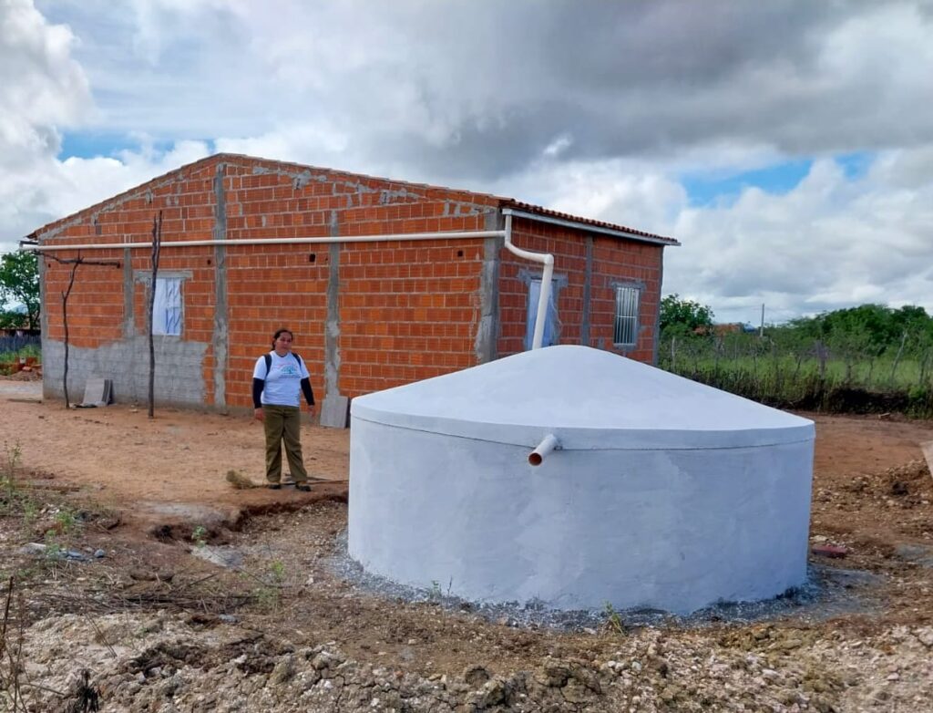 Cisterna de primeira água ao lado de uma casa.