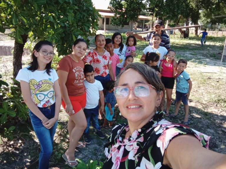 Foto de Solange e os guardiões mirins no quintal agroecológico.