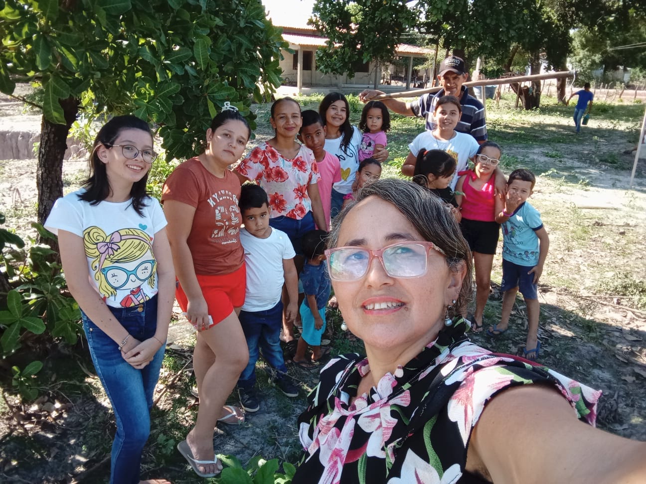 Foto de Solange e os guardiões mirins no quintal agroecológico.
