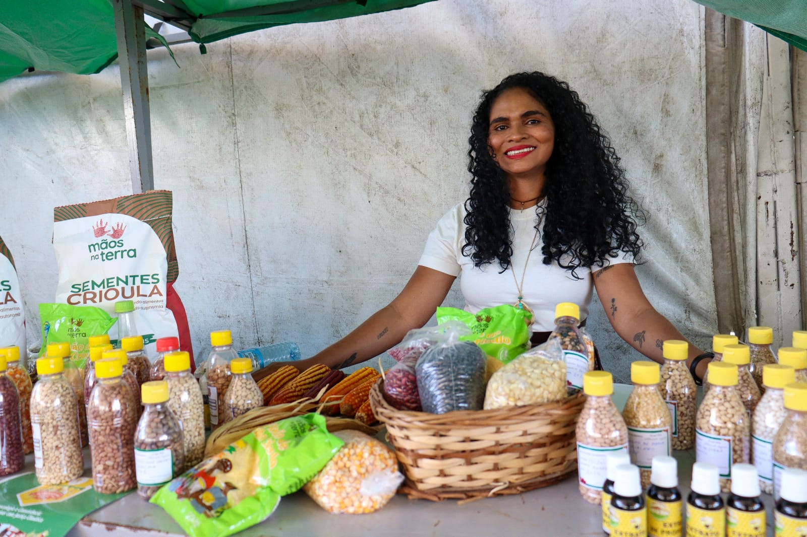 Jovem atrás de uma mesa com sementes crioulas.