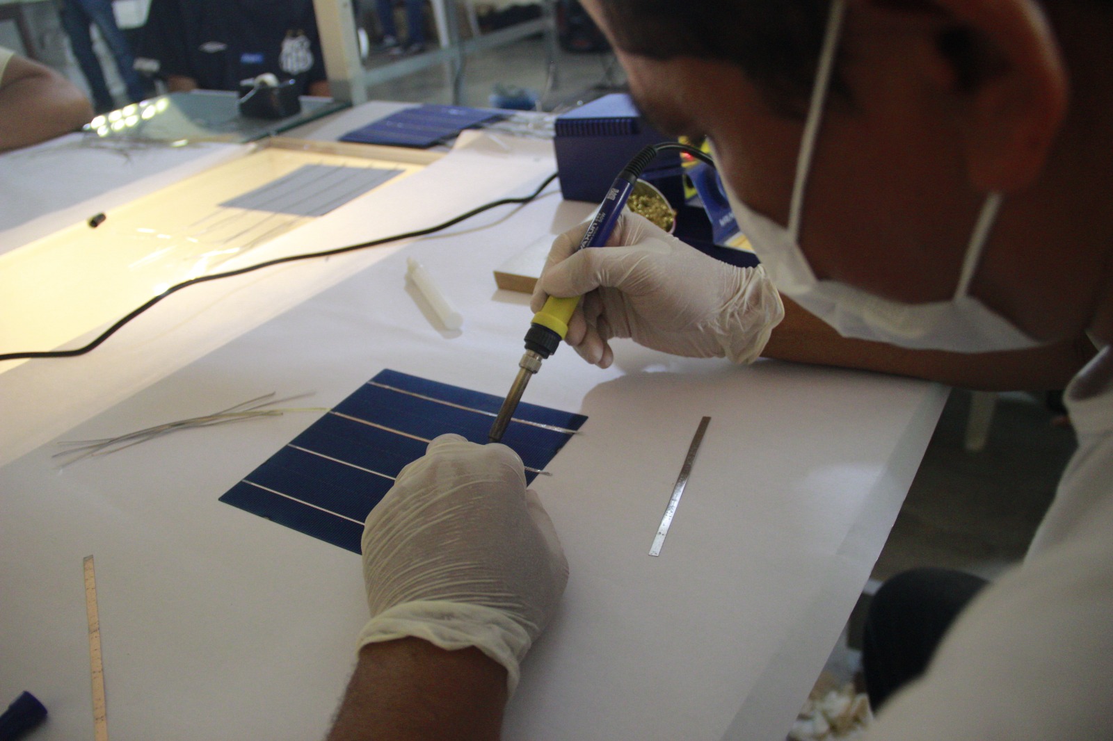 Jovem aprendendo a produzir placas fotovoltaicas | Foto: Instituto I9Sol