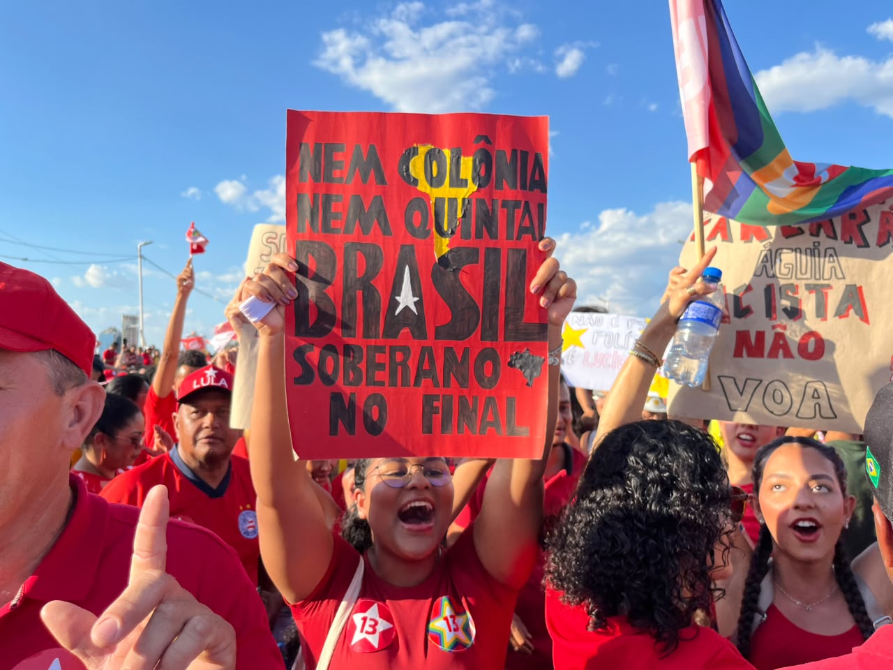 Mulher segurando cartaz com a frase "Nem colônia, nem quintal. Brasil soberano no final" durante o ato de Lula em Juazeiro (BA) e Petrolina (PE).